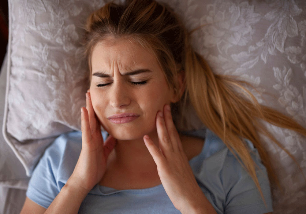 image of a woman holding her cheeks with her hands in pain